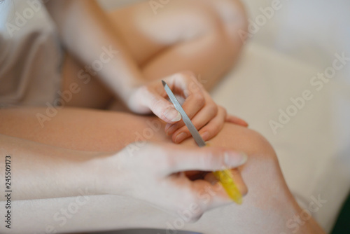 Woman using nailfile during making menicure herself