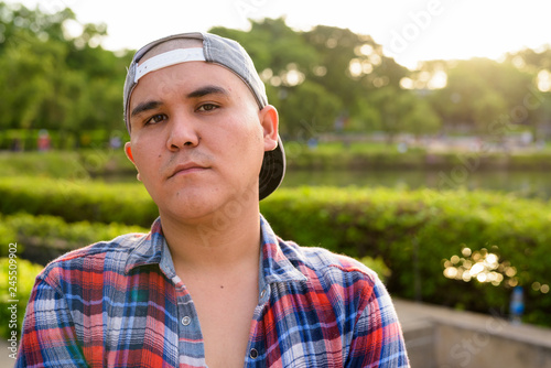 Young Asian man wearing cap while relaxing at the park in Bangko