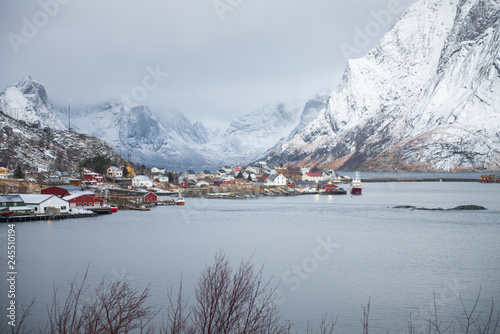 Fishing house village among the snow with mountain view in Lofoten island Reine Norway © magneticmcc