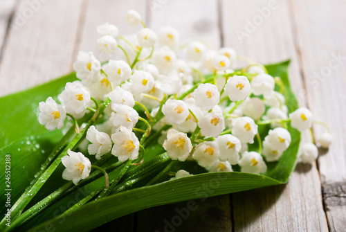 bouquet of lily of the valley on old weathered wooden table background