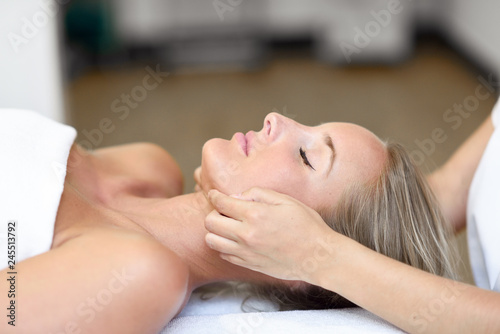 Young woman receiving a head massage in a spa center. photo