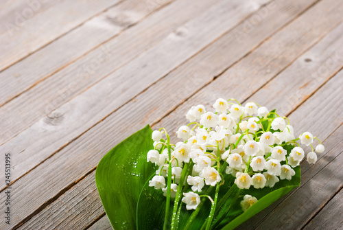 bouquet of lily of the valley on old weathered wooden table background