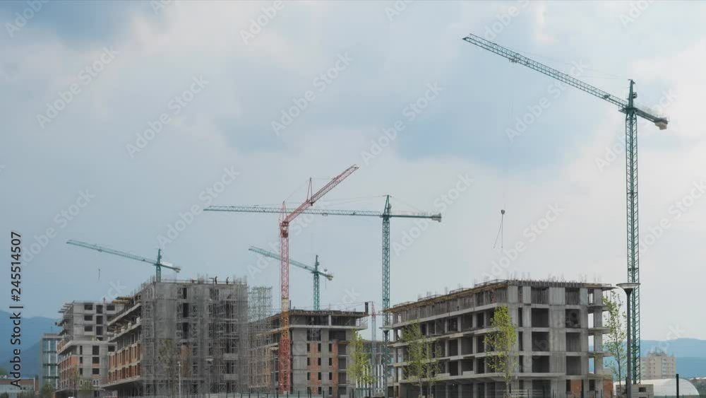 Cranes moving on the sky building new constructions, urban development Cranes moving on the sky building new constructions, urban development
