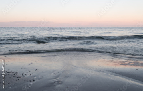 Fototapeta Naklejka Na Ścianę i Meble -  Calm waves in the cold sea on the shores of Gotland in the Baltic Sea. Late one winter afternoon.
