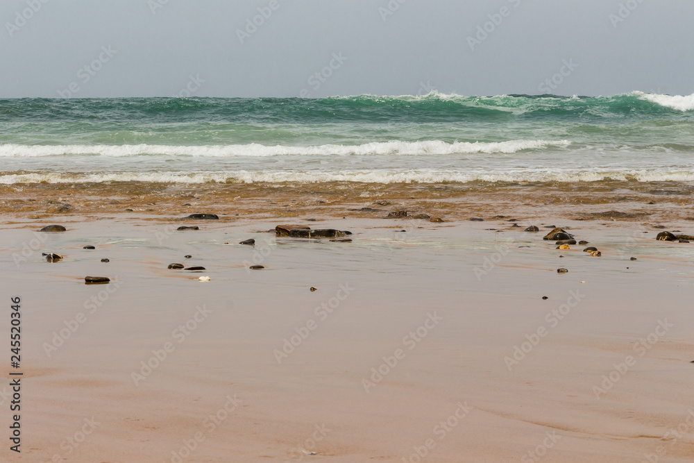 Empty sandy beach. View over the open ocean. Wavy ocean. Cloudy day. Nature scenery. Empty sandy beach. View over the open ocean. Wavy ocean. Cloudy day. Nature scenery.
