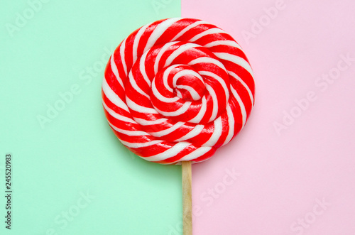 lollipop, a beautiful red and white striped lollipop on a green-pink background