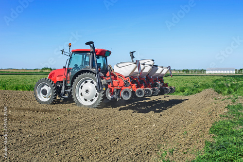 Farmer with a tractor sows corn