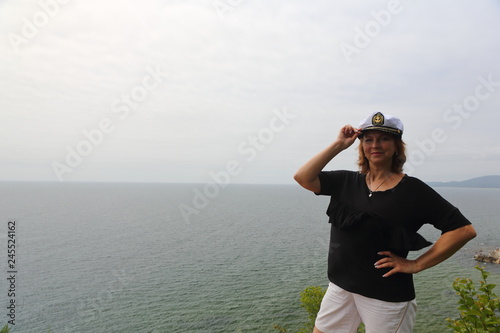 young woman by the sea in a cap