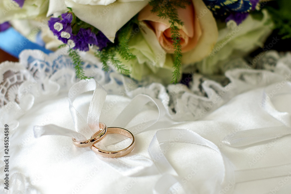 Wedding bouquet with wedding rings. Gold wedding rings lie near the bouquet for the bride. Wedding accessories Wedding bouquet with wedding rings. Gold wedding rings lie near the bouquet for the bride. Wedding accessories