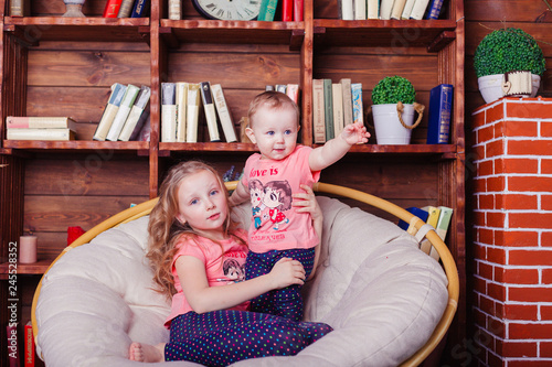 Two little cute adorable little caucasain sisters playing together at home. Happiness, childhood, sisterhood concept  photo