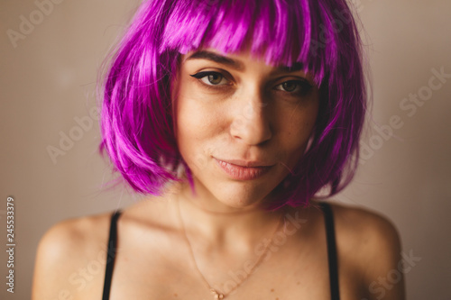 Close up portrait of young woman with pink bob cut and stylish makeup. She look happy, smiling and sexy