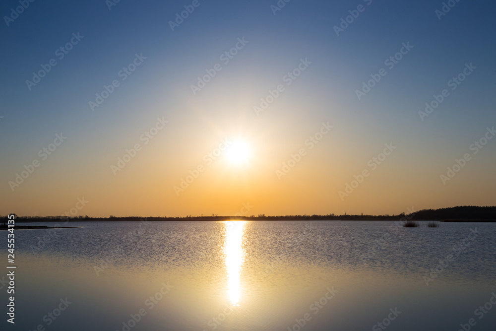 dramatic sunset scene, evening sun reflected in the lake