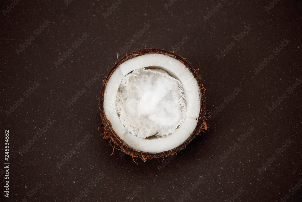 Half coconut on a dark background - obrazy, fototapety, plakaty 