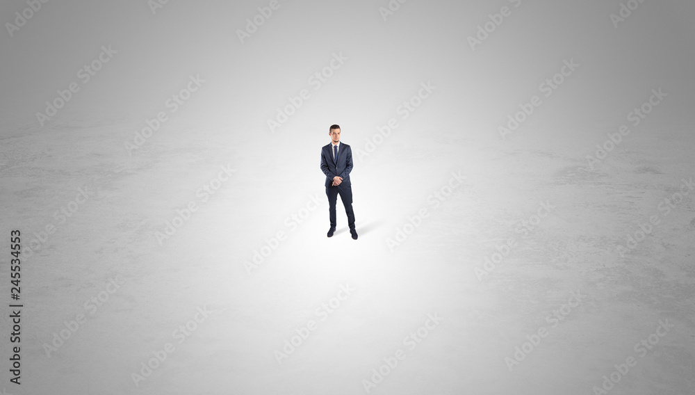 Young businessman standing alone in the middle of an empty space
Young businessman standing alone in the middle of an empty space