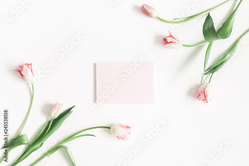 Valentine's Day composition. Tulip flowers, envelope on white background. Valentines day, mothers day, womens day concept. Flat lay, top view, copy space