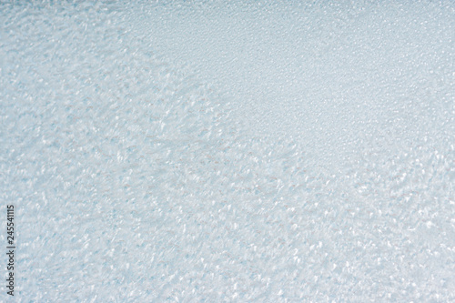 Winter background with gleaming ice. Frozen water texture. Copy space