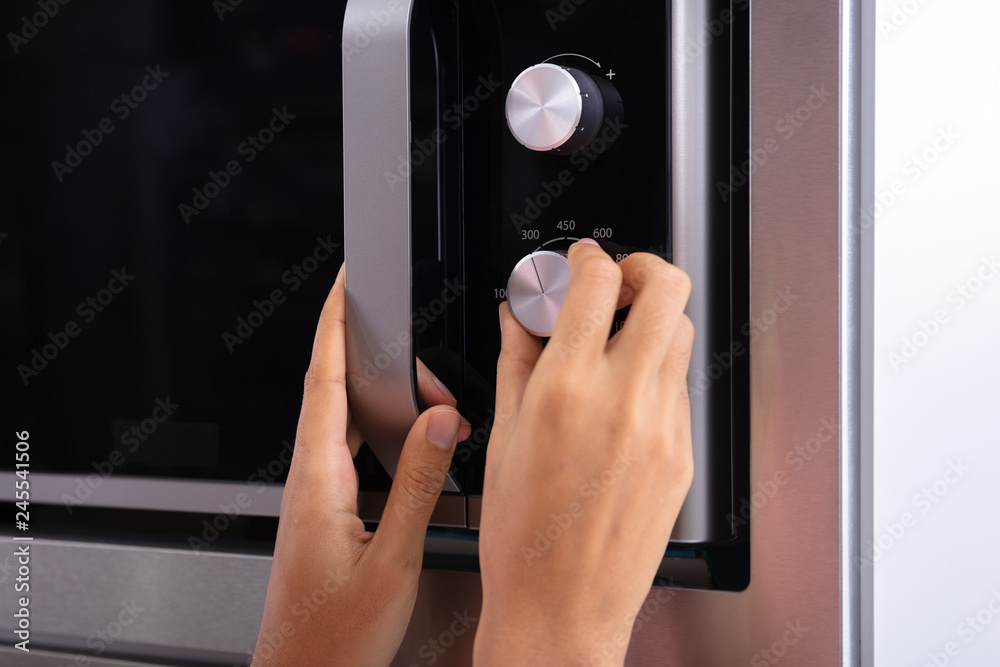 Woman Adjusting Temperature Of Microwave Oven Stock Photo Adobe Stock