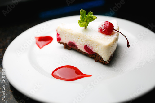 Cheesecake with cherries on a white plate