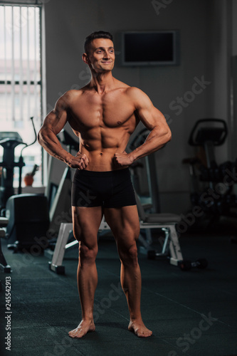 Young fit man doing bodybuilding competition poses