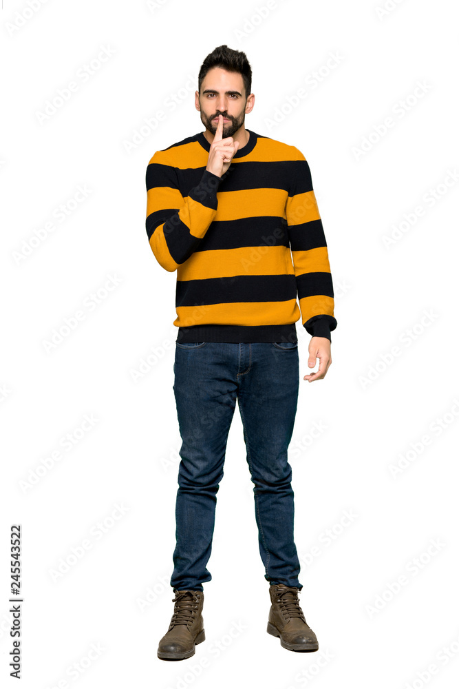 Full-length shot of Handsome man with striped sweater showing a sign of silence gesture putting finger in mouth on isolated white background Full-length shot of Handsome man with striped sweater showing a sign of silence gesture putting finger in mouth on isolated white background