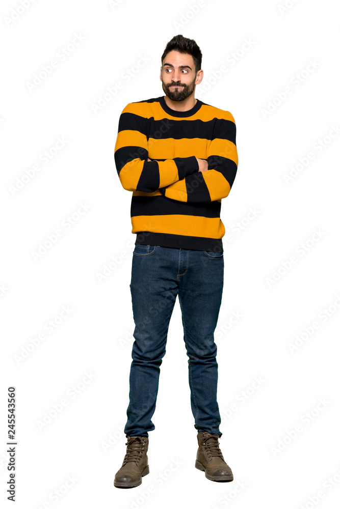 Full-length shot of Handsome man with striped sweater making doubts gesture while lifting the shoulders on isolated white background Full-length shot of Handsome man with striped sweater making doubts gesture while lifting the shoulders on isolated white background