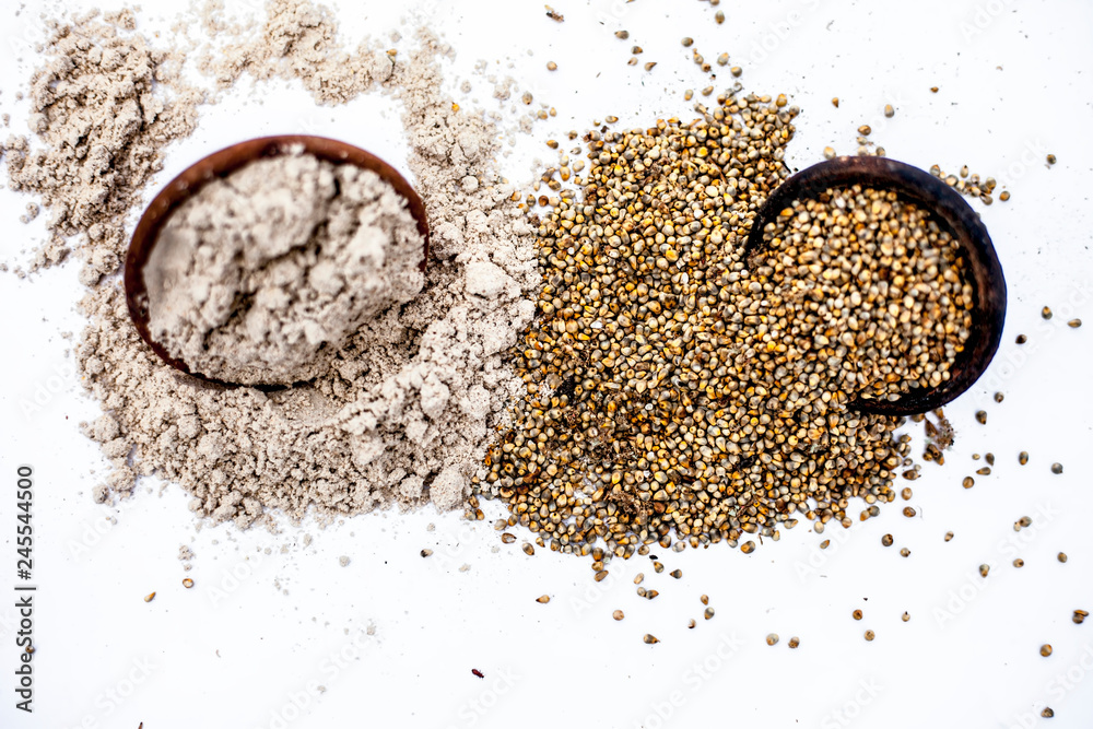 Φωτογραφία Close up of clay bowl of barley or pearl millet with its flour in a another bowl isolated on white