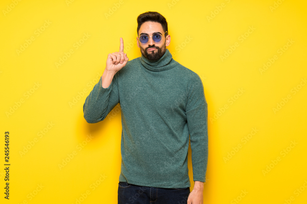 Handsome man with sunglasses thinking an idea pointing the finger up Handsome man with sunglasses thinking an idea pointing the finger up