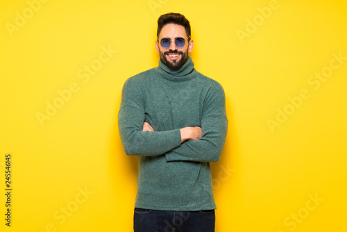 Handsome man with sunglasses keeping the arms crossed in frontal position