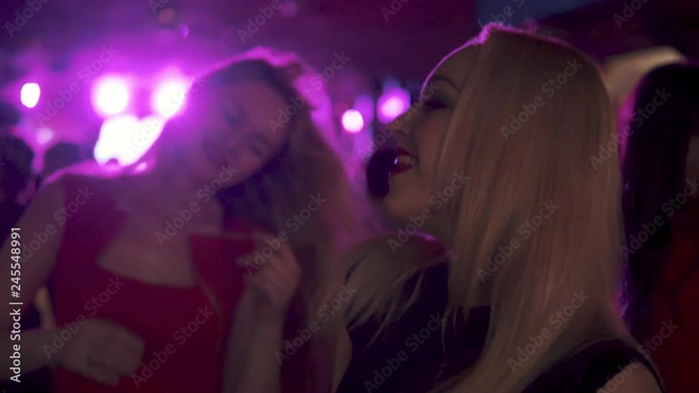 young woman dancing among a crowd of people young woman dancing among a crowd of people