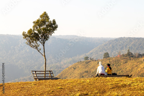 Photos Young couple sitting on a sunrise view point at Phu Lom Lo mountain in Loei Province, Thailand
