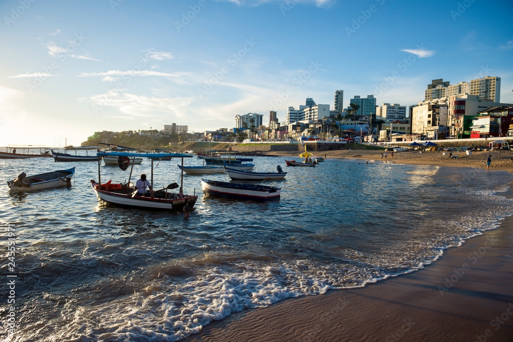Scenic afternoon view of traditional Brazilian fishing boats anchored off the shore of Rio Vermelho beach, a coastal neighborhood in Salvador, Bahia, Brazil