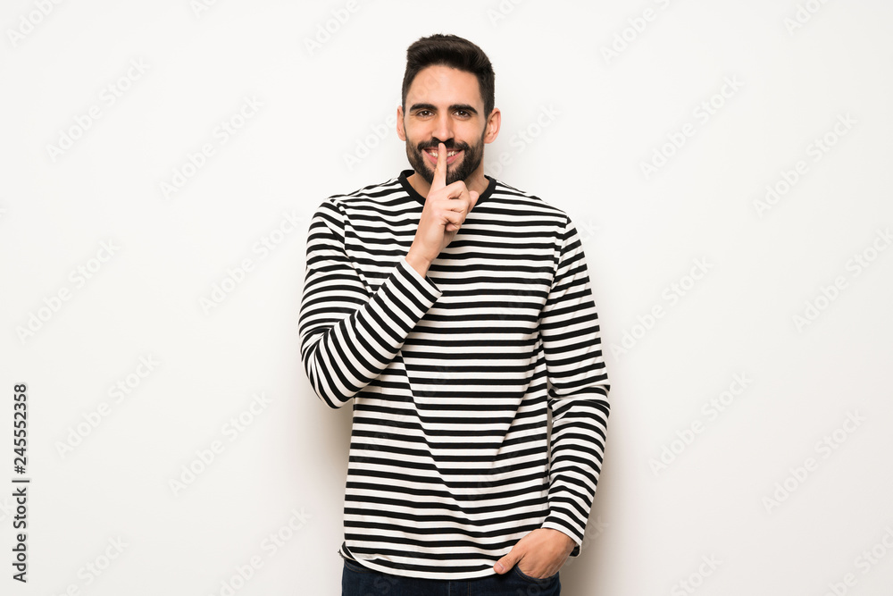handsome man with striped shirt showing a sign of silence gesture handsome man with striped shirt showing a sign of silence gesture