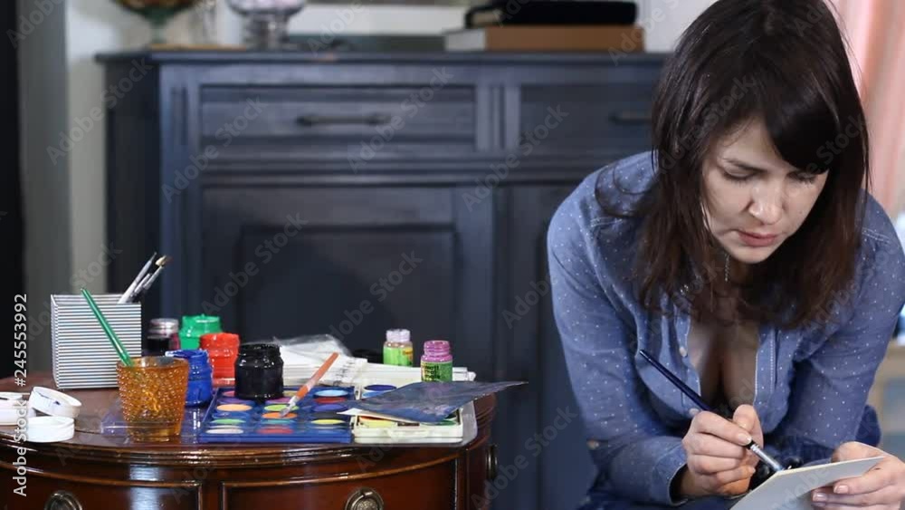 cheerful woman artist painting in her art studio cheerful woman artist painting in her art studio