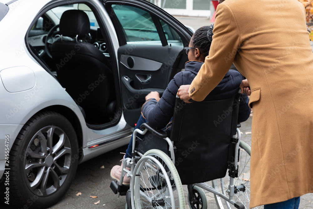 Man With Her Disabled Wife Moving Towards Car