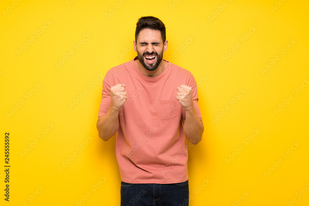 Handsome man over yellow wall frustrated by a bad situation Handsome man over yellow wall frustrated by a bad situation