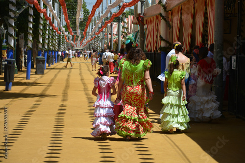 Fototapeta the families with the flamenco dress at Feria de Abril in Seville, Spain