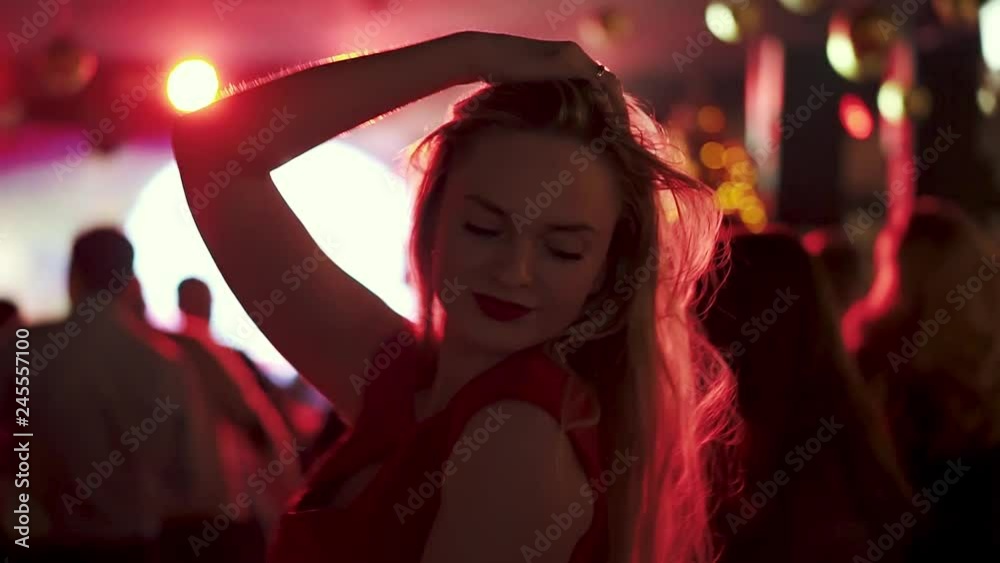 portrait of a young woman dancing at a party amid a crowd of people portrait of a young woman dancing at a party amid a crowd of people