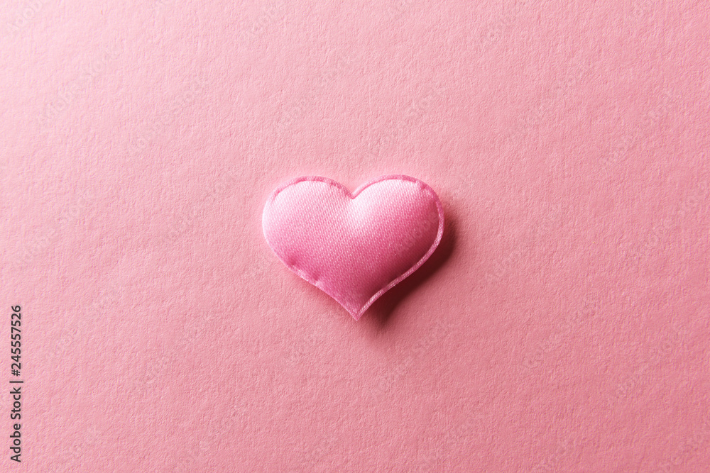 Pink textile heart on pink background. Valentines day texture and love concept Pink textile heart on pink background. Valentines day texture and love concept