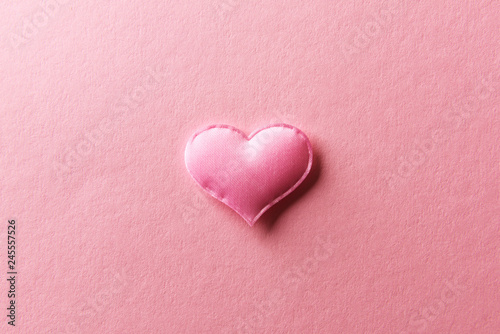 Pink textile heart on pink background. Valentines day texture and love concept