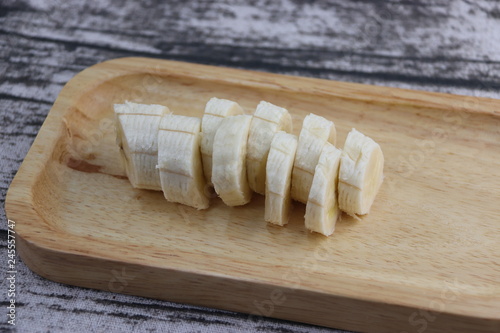 Tranches de banane découpés sur un plateau en bois photo