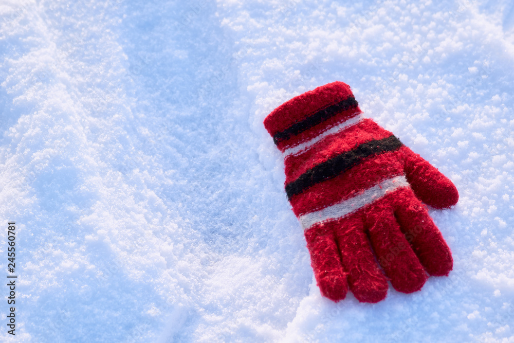 lonely Red winter glove lying in the snow forgotten hostess. warm winter concept