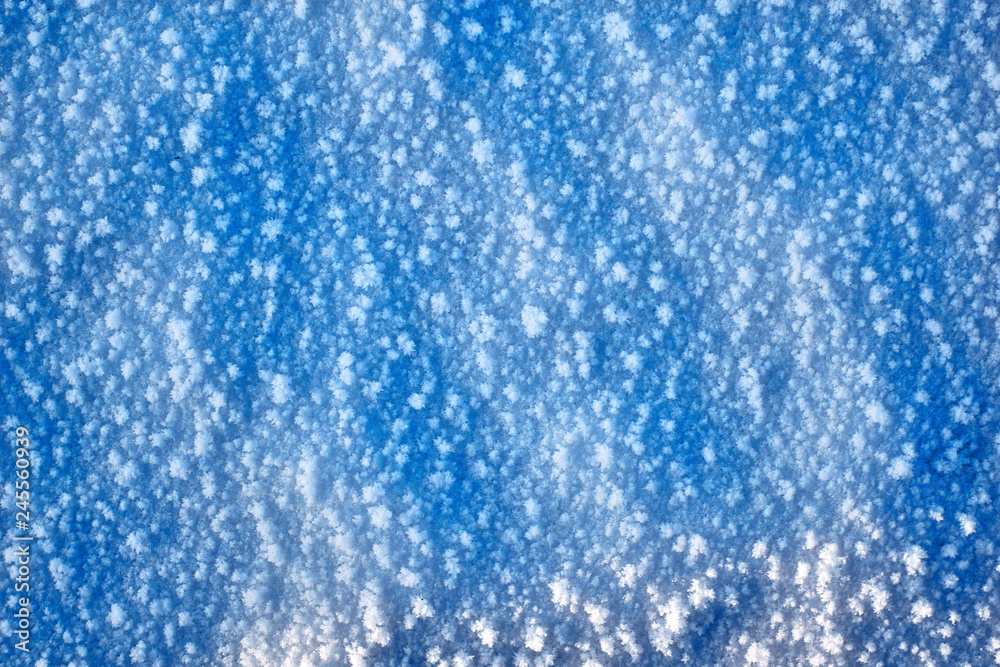 Abstraction of blue winter snow for a background. large large snowflakes. concept winter natural background