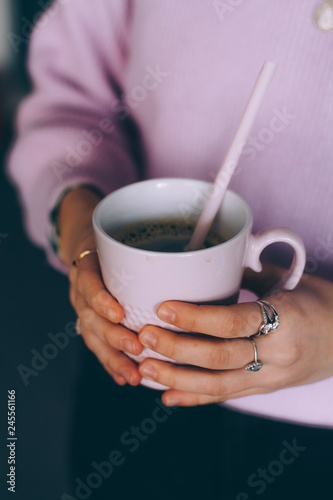 A Cup of hot coffee in women's hands close-up
