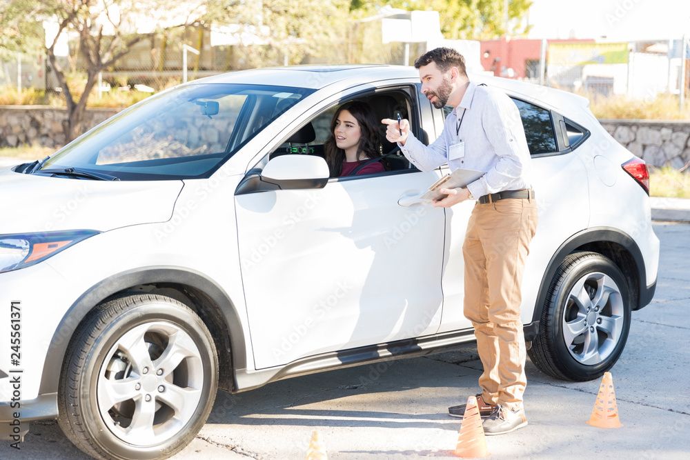 Auto Trainer And Student Communicating During Driving Lessons Auto Trainer And Student Communicating During Driving Lessons