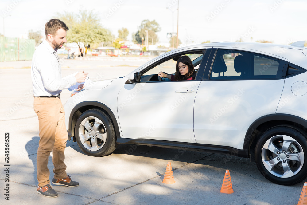 Driving Teacher Assisting Woman In Parking Car Driving Teacher Assisting Woman In Parking Car