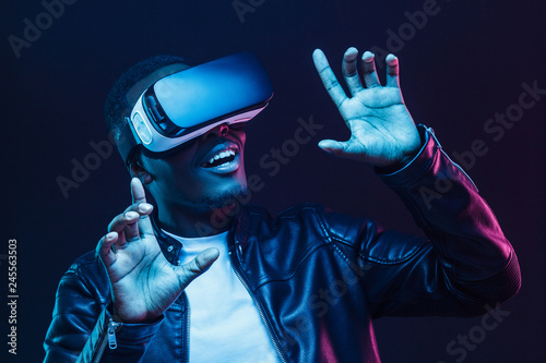 Young african man having virtual reality experience using vr headset photo
