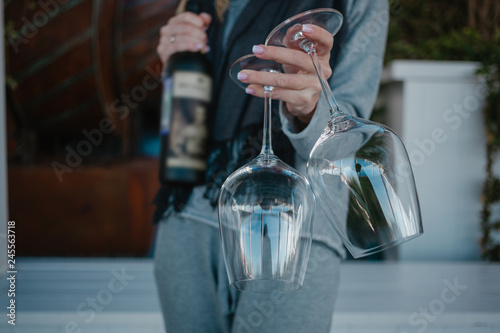 woman hold two empty glasses and bottle of wine