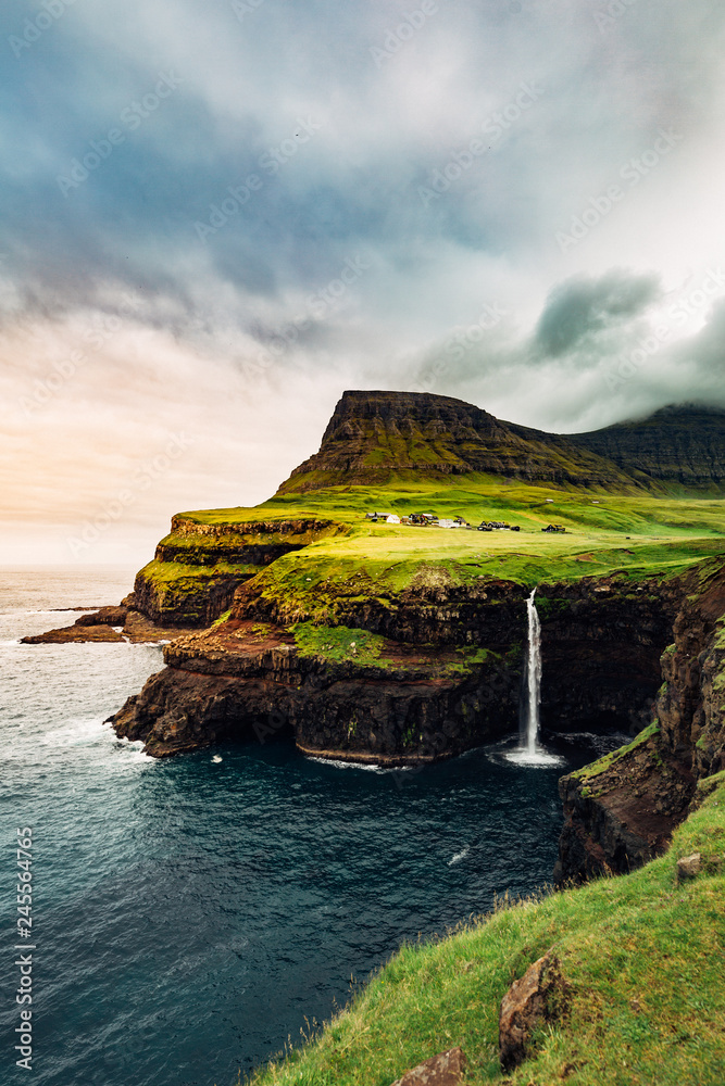 Gasadalur Waterfall at the Faroe Islands in a cloudy day