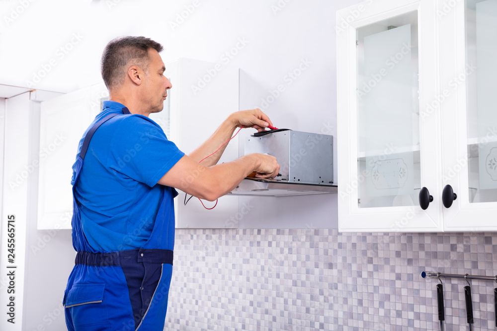 Technician Checking Extractor Filter With Digital Multimeter