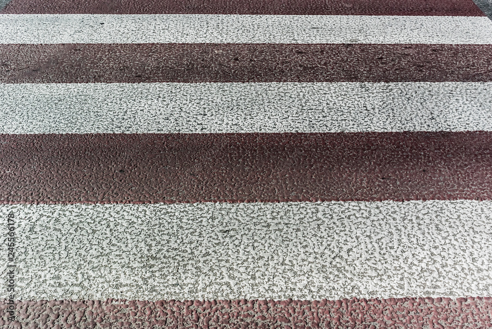 Contrast photo stylized as a retro of partially faded white-red pedestrian crossing on asphalt Contrast photo stylized as a retro of partially faded white-red pedestrian crossing on asphalt